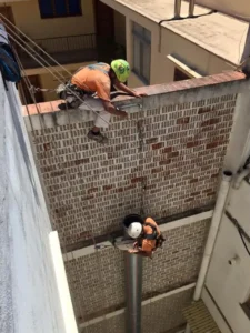 Trabajadores instalando una bajante en un patio interior