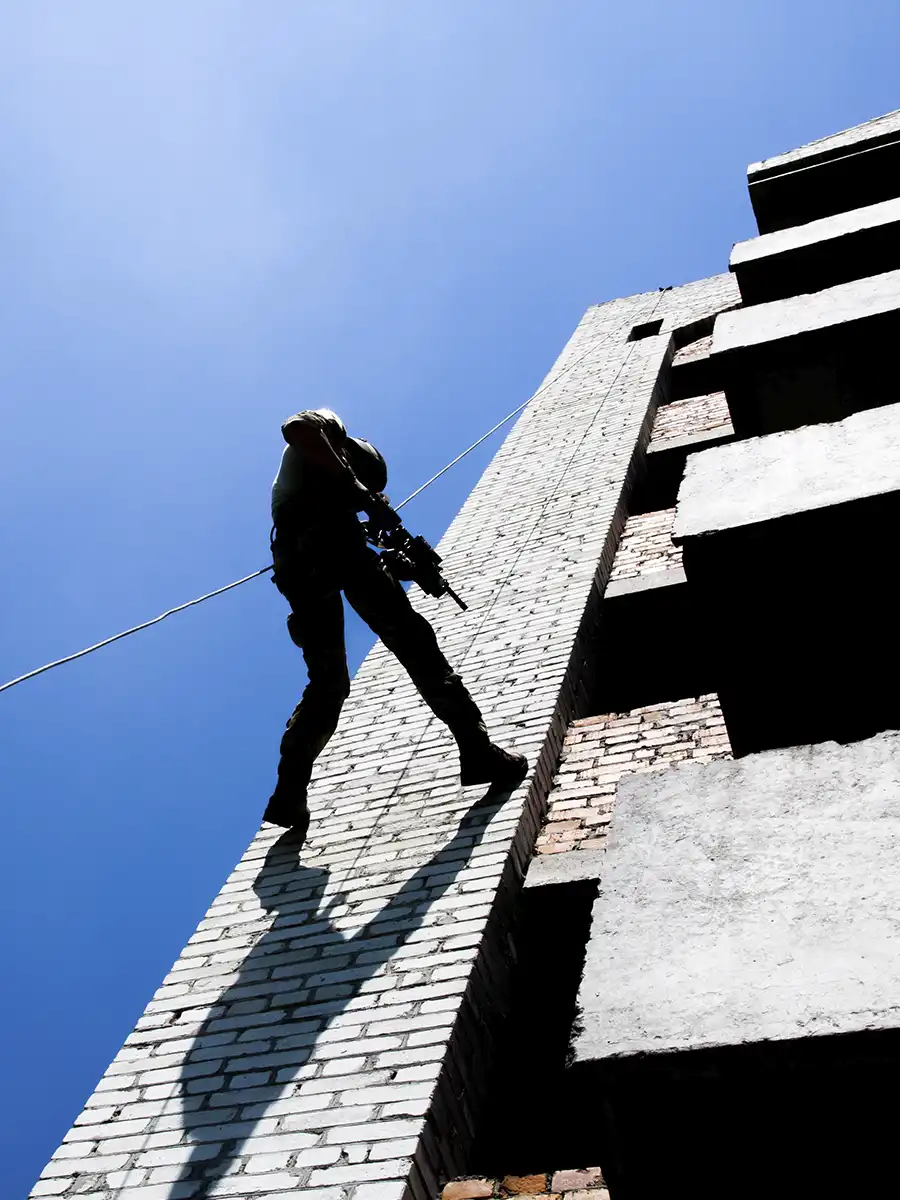 Trabajador en fachada con línea de vida y taladro percutor